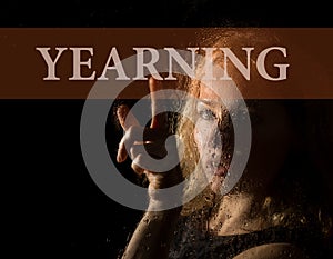 Yearning written on virtual screen. hand of young woman melancholy and sad at the window in the rain