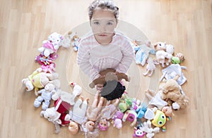 5 years little girl unhappy with lots of toys. Too many toys concept at Infant Behaviour photo