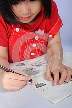 3 years old asian girl draws and sketchs many human faces with p photo