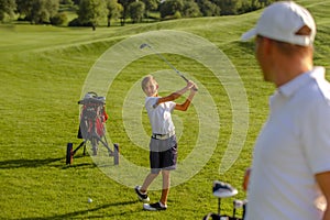 11 years old boy practice golf hits at golf course
