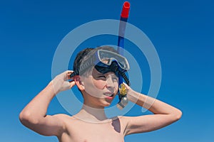 13 years old boy in the snorkeling mask and tube for diving in the sea wave. Travel and summer concept. photo