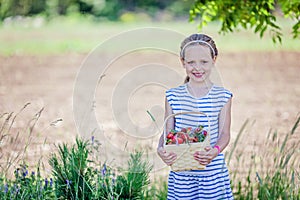 7 years old girl holding basket full of strawberries