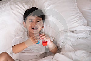 3 years old little cute Asian boy at home on the bed, kid lying