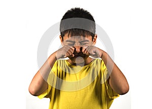 7 or 8 years old male child crying helpless and sad isolated on white background wearing yellow t-shirt in kid scolded and nagged photo