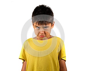 8 years old male child sad and ashamed after suffering reprimand isolated on white background wearing yellow t-shirt in emotional photo
