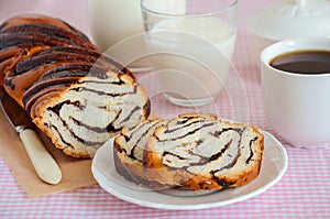 Yeast roll with chocolate and poppy seed with tea and milk.