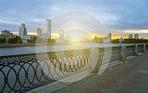 Yekaterinburg city center on sunset. City pond view, amazing clouds and sky. High buildings, skyscrapers on the embankment of the