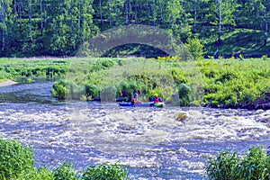 Yekaterinburg, Russia - June 8, 2019: Extreme whitewater rafting trip. A group of people team in kayaks practise traversing the