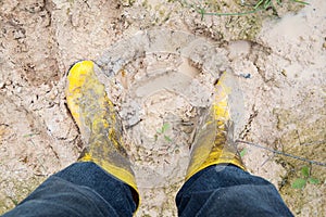 Yelkow Muddy rubber boots on wet silt