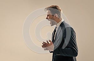 Yelling and screaming. Angry businessman scream grey background. Screaming guy stand sideway