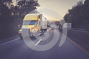 Yellow 18 wheeler semi truck on highway
