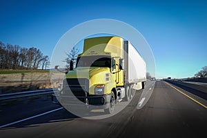 Yellow 18-wheeler semi truck on highway delivering freight