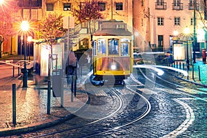 Yellow 28 tram in Alfama at night, Lisbon, Portugal
