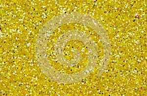 Yellow abstract background. Gold glitter closeup photo. Golden shimmer wrapping paper.