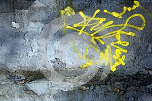 Yellow abstract stain from spray stripe on textured grunge grayish wall