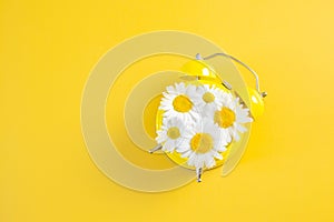 Yellow alarm clock with daisies instead of a dial.