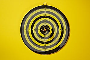 Yellow arrow dart hitting the center of the target dartboard