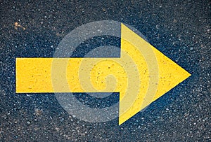 Yellow arrow painted in asphalt road. Direction sign for pilgrims in Saint James way, Camino de Santiago de Compostela, Spain
