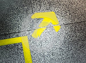 Yellow arrow sign indicate on marble floor