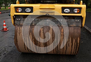 Yellow asphalt roller standing on asphalt