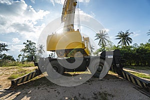 Yellow automobile crane with risen telescopic boom outdoors. Mobile construction crane on a constructin site. Crane