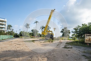 Yellow automobile crane with risen telescopic boom outdoors. Mobile construction crane on a constructin site. Crane