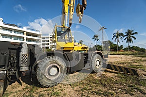 Yellow automobile crane with risen telescopic boom outdoors. Mobile construction crane on a constructin site. Crane