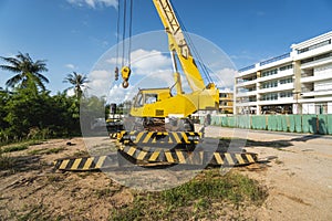 Yellow automobile crane with risen telescopic boom outdoors. Mobile construction crane on a constructin site. Crane