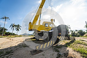 Yellow automobile crane with risen telescopic boom outdoors. Mobile construction crane on a constructin site. Crane