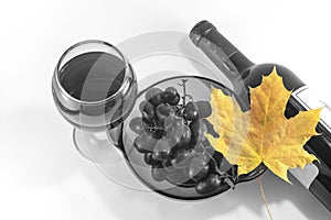 Yellow autumn leaf on the background of a black and white image of a wine glass and bottle