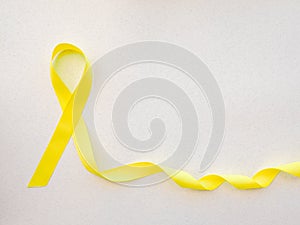 Yellow awareness ribbon on light background, Yellow ribbon symbolic color for Sarcoma Bone cancer, Spina Bifida Awareness Month