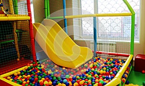 Yellow baby slide going down to the pool with many colored ball