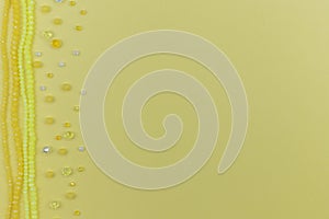 yellow beads and crystals frame on yellow with copy space