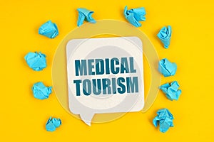 On a yellow background, blue pieces of paper and a sign with the inscription - Medical Tourism