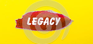 On a yellow background, a sheet of red paper with the word LEGACY