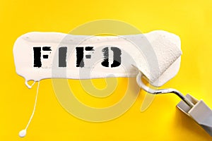 On a yellow background, the surface is painted white with a brush, on which it is written FIFO