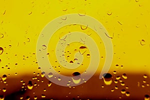 Yellow background with water drops on the glass. The heel is design for beer.