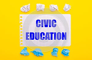 On a yellow background, white and blue crumpled pieces of paper and a notebook with the text CIVIC EDUCATION