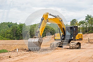 Yellow backhoe excavating soil and sand