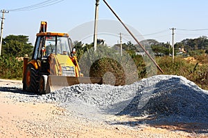 Yellow Backhoe Loader in Road Construction