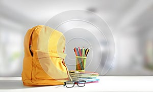 Yellow backpack on table empty copy space. School supplies. Education objects