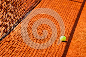 Yellow ball on a clay tennis court.