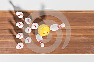 Yellow ball hitting pins on wooden bowling alley