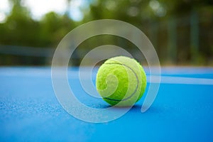 Yellow ball on blue tennis court background. photo