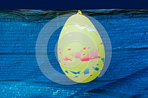 Yellow balloon on blue plastic background