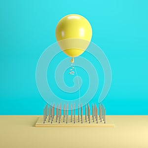 Yellow balloon floating above nail traps on blue pastel background color