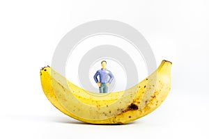 Yellow Banana and miniature models on White Background. Healthy lifestyle, fruit concept. Shallow depth of field, soft focus