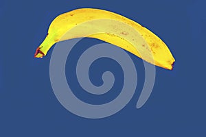 Yellow banana shape on classic blue background. Banana Minimal. Pastel colors style. Popart. Digitalart. Surreal. Pop photo