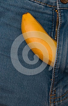 Yellow banana sticks out of a zipper blue pants jeans  copy space