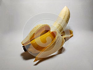 Yellow banana on a white background peeled
